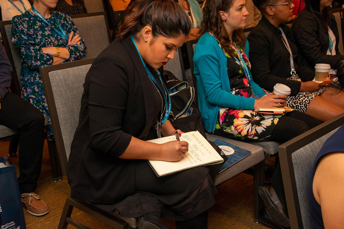 Summit participant taking notes during a session